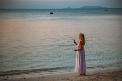 Vrouw in telefoongesprek op strand